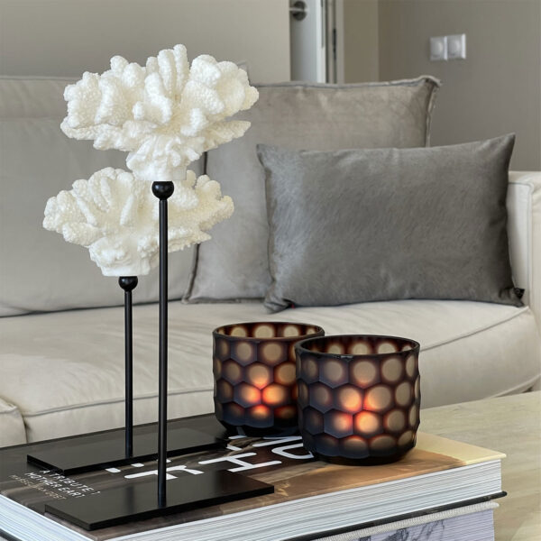 Bruine glazen waxinelichthouders op salontafel in warm interieur